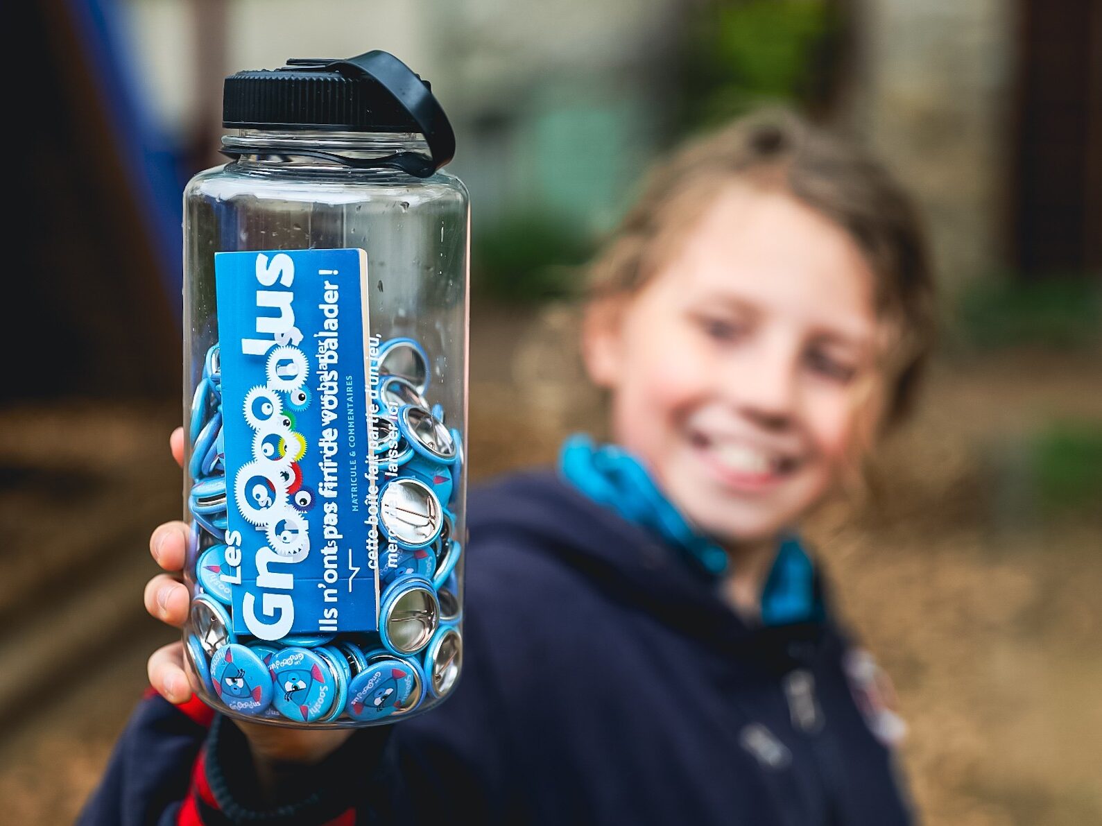 Un enfant tenant une bouteille Gnolus dans sa main, fier d'avoir capturé Sooshi à Orliénas !