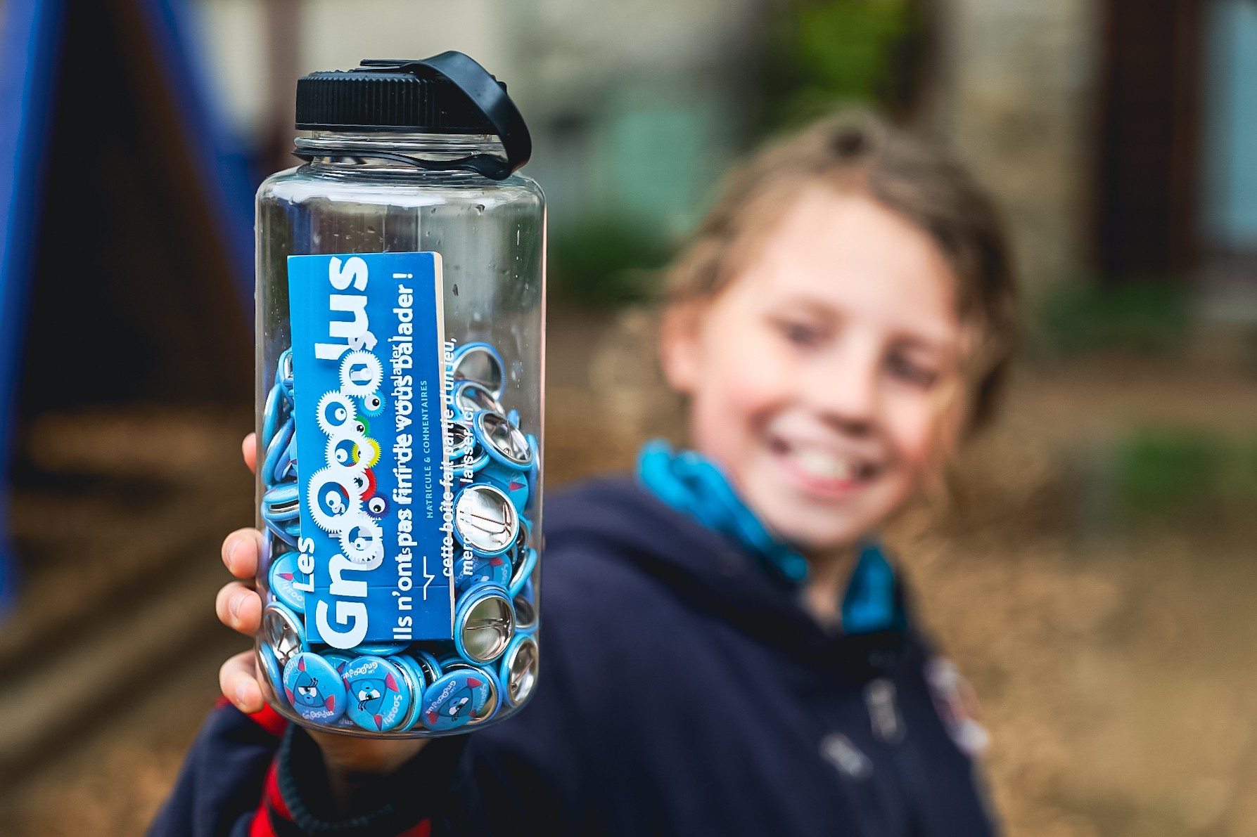 Un enfant tenant une bouteille Gnolus dans sa main, fier d'avoir capturé Sooshi à Orliénas !