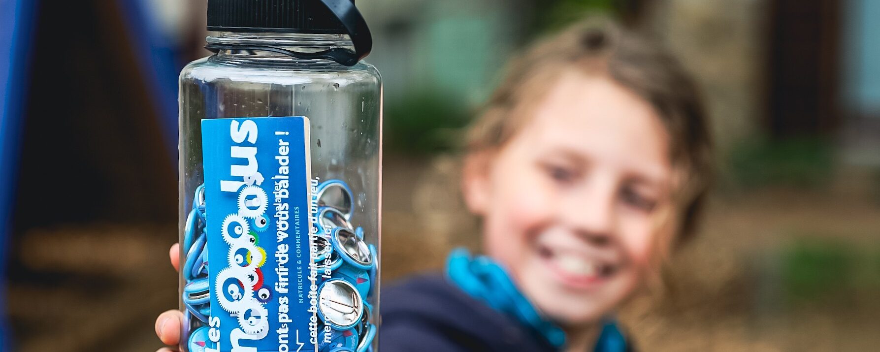 Un enfant tenant une bouteille Gnolus dans sa main, fier d'avoir capturé Sooshi à Orliénas !