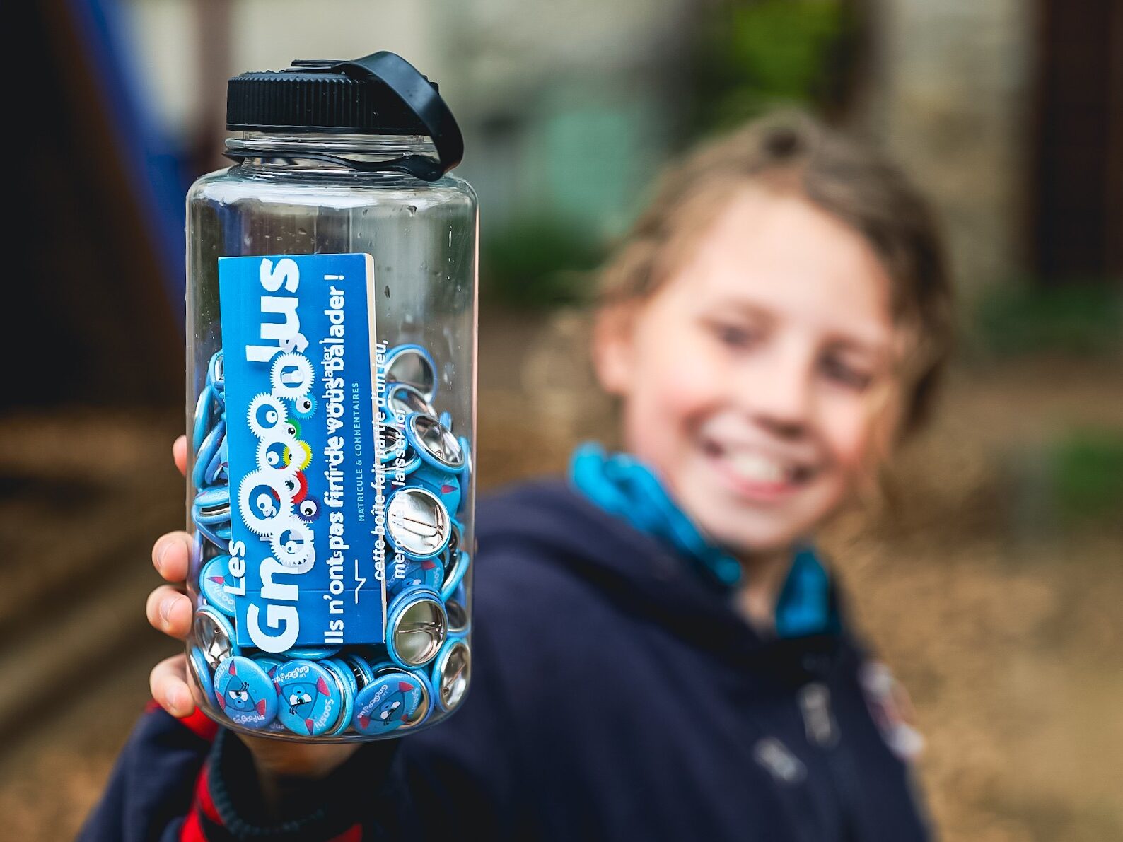Un enfant tenant une bouteille Gnolus dans sa main, fier d'avoir capturé Sooshi à Orliénas !